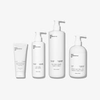 The Complete Skin Savior Set by Basic Maintenance features four white minimalist containers—a tube, two pump bottles of varying sizes, and a rounded pump bottle—displayed on a plain white background.