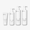 Four white bottles from Basic Maintenances Face + Hair Rescue Team—each with black text: a tube, and pump bottles labeled The Face Wash, The Serum, and The Conditioner.