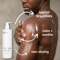 A man applies Basic Maintenance The Body Wash to his shoulder; arrows and text highlight its benefits: “banish breakouts,” “calm + soothe,” and “non-drying,” while a bottle of the body wash is shown in the foreground.