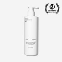 A white pump bottle labeled “The Conditioner” by Basic Maintenance stands on a white background, with a 2023 Best Conditioner award badge in the top right corner.