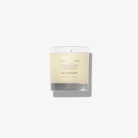 The Calm candle by Basic Maintenance features minimalist text on a clear glass container, casting a soft shadow on a white background.